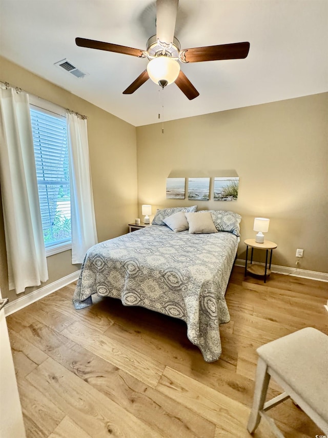 bedroom featuring baseboards, wood finished floors, and ceiling fan