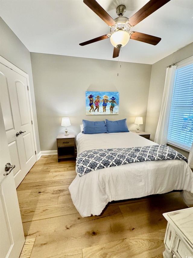 bedroom featuring light wood-style flooring, baseboards, and a ceiling fan