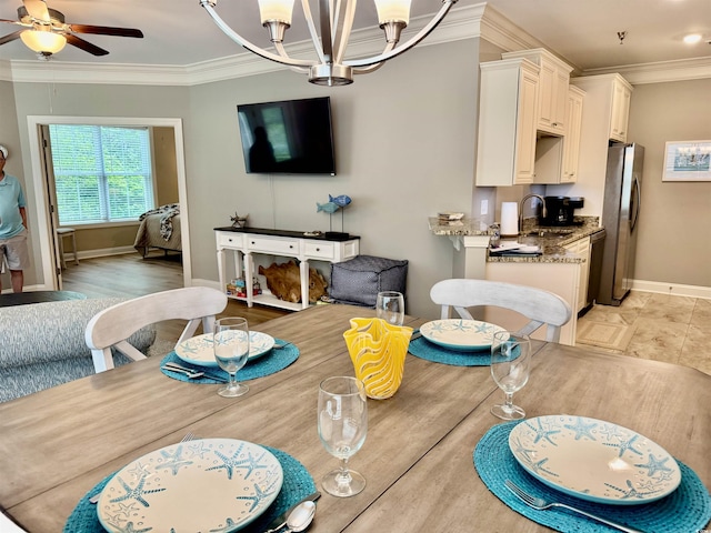 dining area featuring baseboards, crown molding, a chandelier, and a ceiling fan