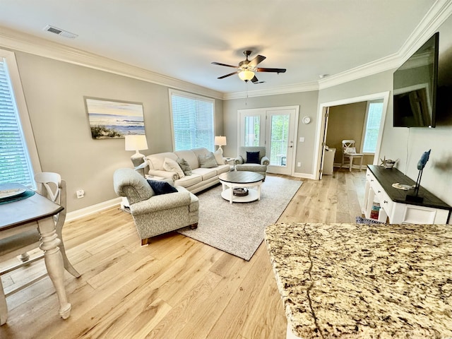living room featuring crown molding, light wood-style floors, ceiling fan, and baseboards