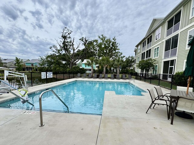 community pool featuring fence and a patio