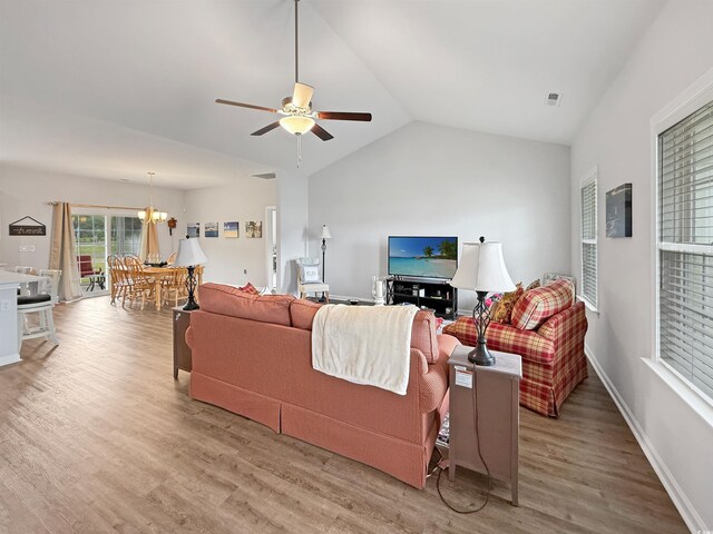 living room featuring ceiling fan, light wood-style flooring, vaulted ceiling, a chandelier, and recessed lighting
