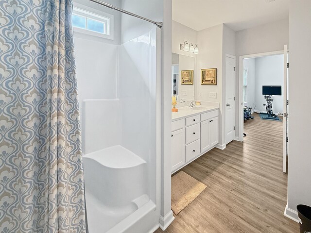clothes washing area with washer and clothes dryer, light wood finished floors, and baseboards