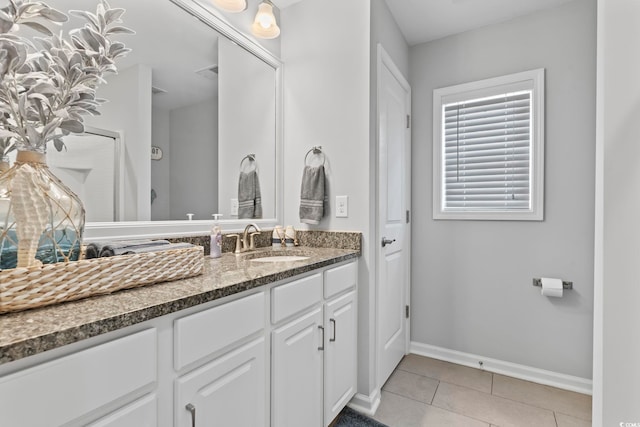 bathroom with baseboards, tile patterned flooring, and vanity