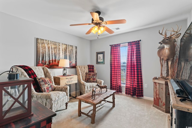 living area with light carpet, a ceiling fan, and baseboards