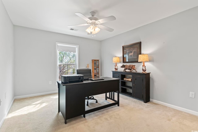 office space with light carpet, baseboards, and a ceiling fan