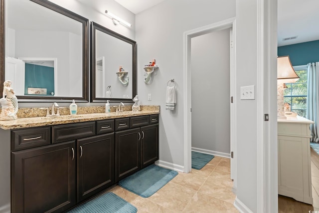 full bathroom featuring double vanity, baseboards, and tile patterned flooring