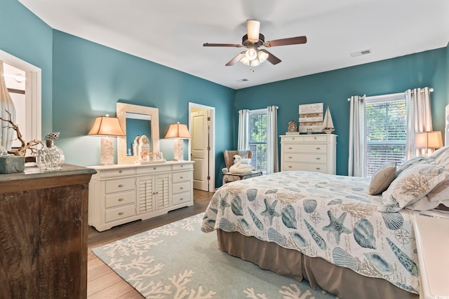bedroom featuring multiple windows, wood finished floors, and ceiling fan
