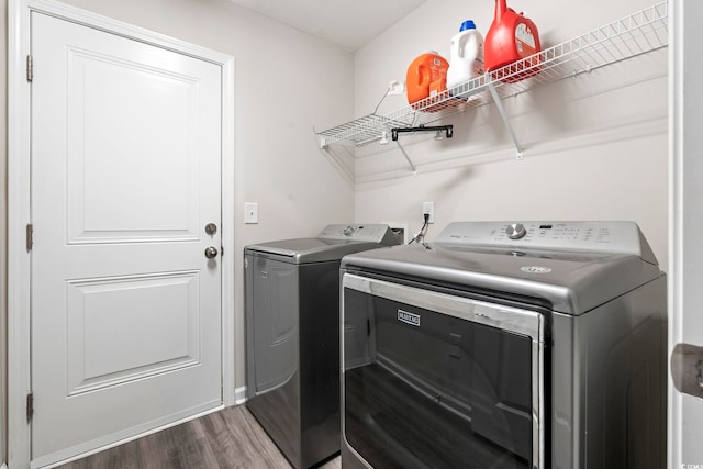 laundry room with washer and clothes dryer and dark wood-style floors