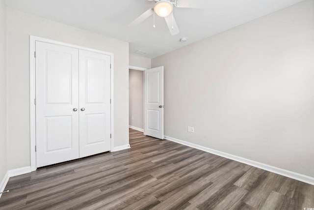 unfurnished bedroom featuring wood finished floors, baseboards, a closet, and ceiling fan