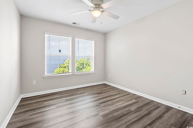spare room featuring dark wood finished floors, baseboards, and ceiling fan