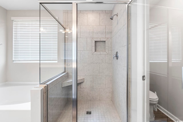full bathroom with a stall shower, a garden tub, and toilet