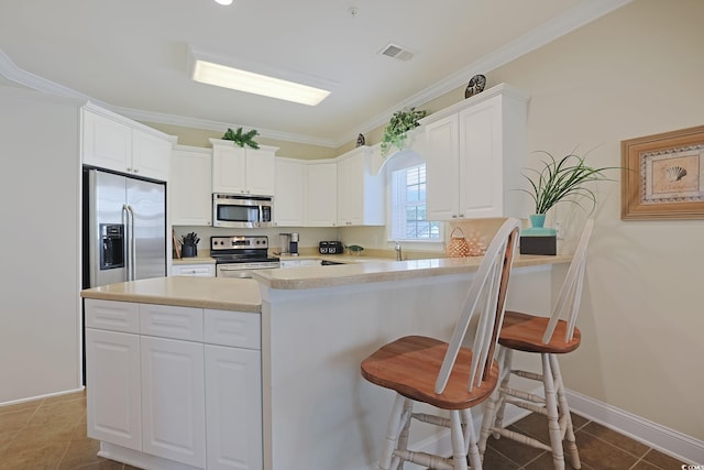 719 Shearwater Ct Unit 301, Murrells Inlet, SC 29576 - kitchen featuring stainless steel appliances, crown molding, light countertops, a kitchen breakfast bar, and white cabinetry