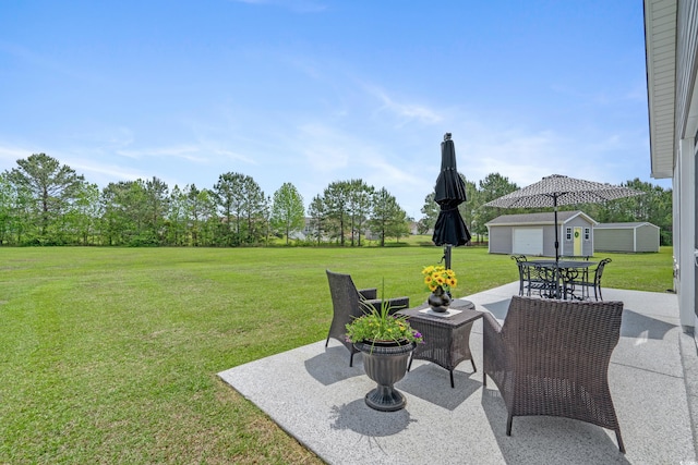 view of green lawn with a patio and an outbuilding