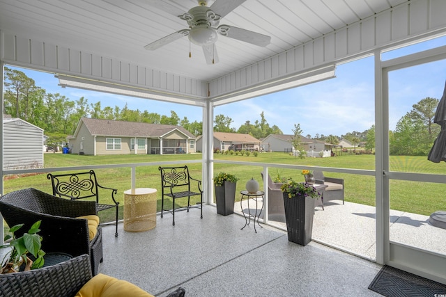 sunroom / solarium with a ceiling fan and a residential view