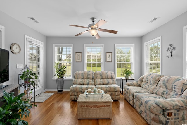 living area with hardwood / wood-style flooring, healthy amount of natural light, and ceiling fan