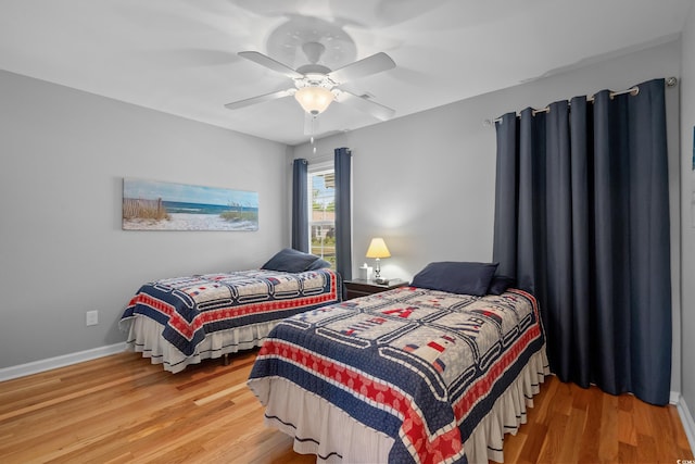 bedroom with wood finished floors, ceiling fan, and baseboards