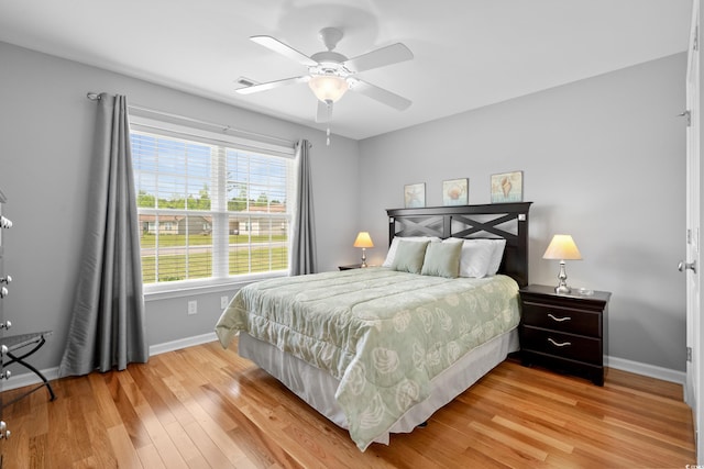 bedroom with baseboards, light wood finished floors, and ceiling fan