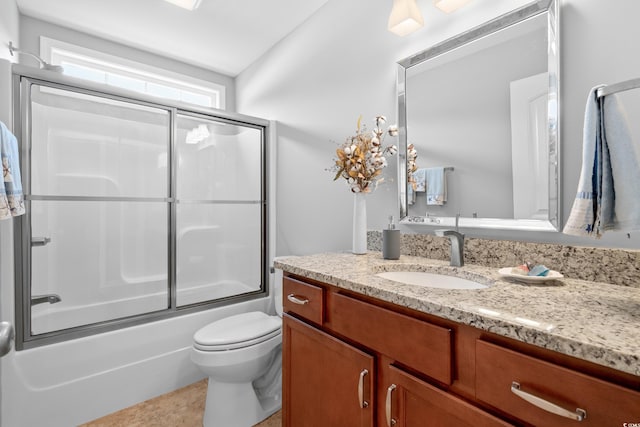 full bath with toilet, vanity, combined bath / shower with glass door, and tile patterned flooring