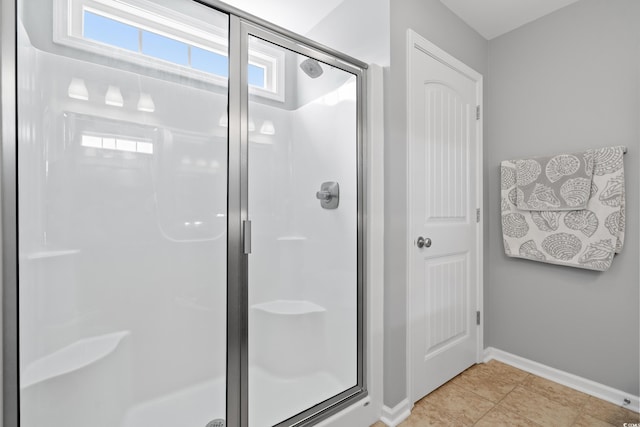 full bath featuring a stall shower and baseboards