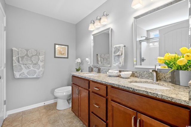 bathroom with a shower stall, baseboards, double vanity, toilet, and tile patterned floors