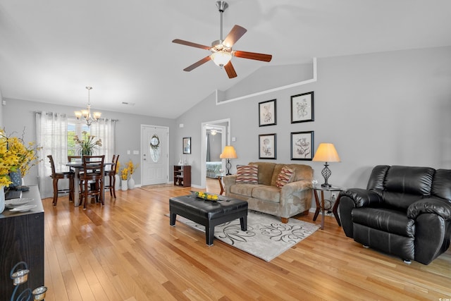 living room with a chandelier, light wood-style flooring, ceiling fan, and vaulted ceiling