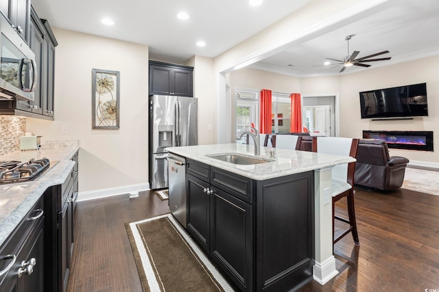 1681 Suncrest Dr, Myrtle Beach, SC 29577 - kitchen with a sink, stainless steel appliances, dark cabinetry, a kitchen breakfast bar, and baseboards