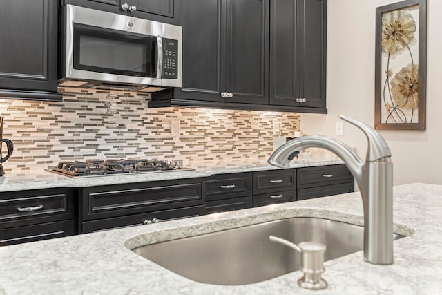 1681 Suncrest Dr, Myrtle Beach, SC 29577 - kitchen featuring stainless steel appliances, dark cabinets, a sink, and tasteful backsplash