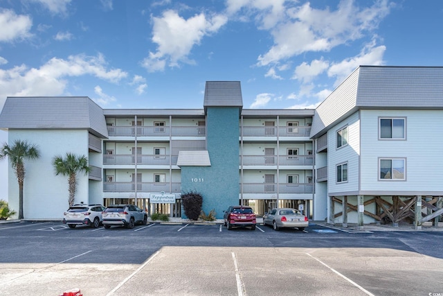 view of apartment building / complex with uncovered parking
