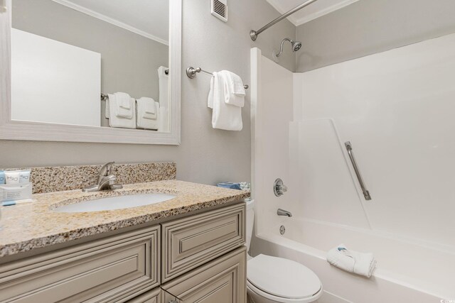 full bath featuring crown molding, toilet, vanity, and bathtub / shower combination