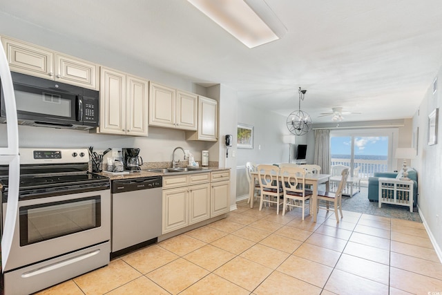 kitchen with appliances with stainless steel finishes, cream cabinets, and a sink