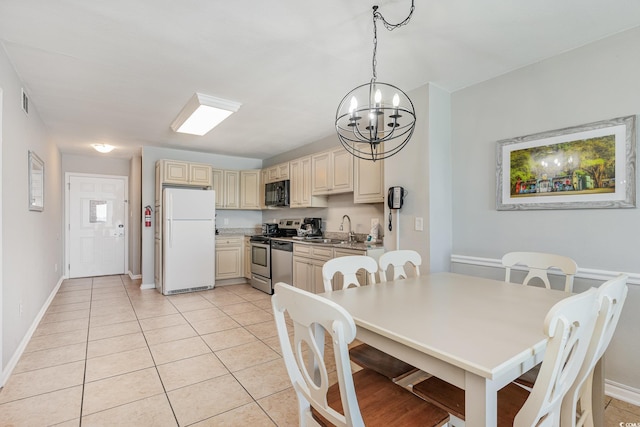 dining room featuring a chandelier, light tile patterned flooring, and baseboards