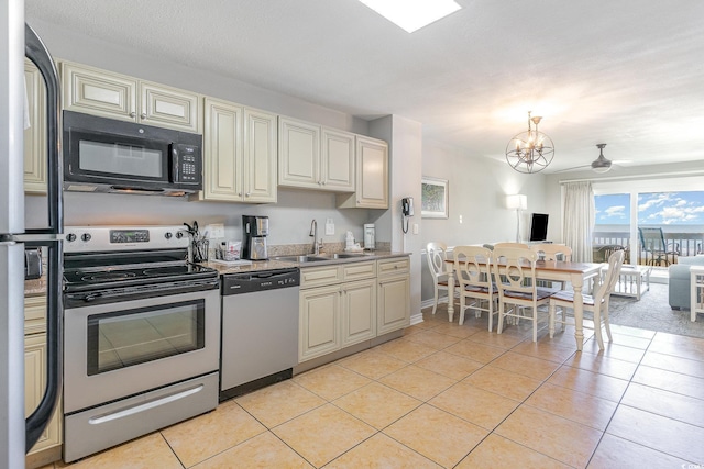 kitchen featuring stainless steel appliances, a sink, light tile patterned floors, and light countertops