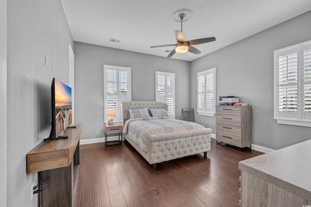 bedroom with multiple windows, dark wood-type flooring, and baseboards