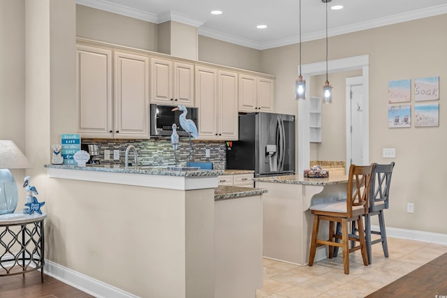 kitchen featuring stainless steel appliances, a peninsula, a kitchen bar, decorative backsplash, and ornamental molding