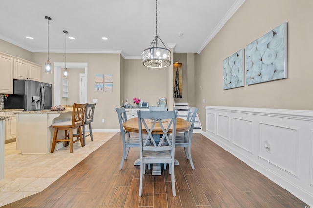 dining space with crown molding, recessed lighting, a chandelier, and light wood-style floors
