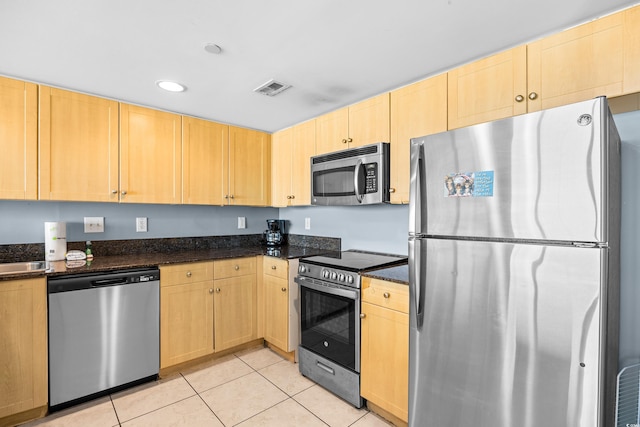 107 S Ocean Blvd Unit 1402, Myrtle Beach, SC 29577 - kitchen with appliances with stainless steel finishes, light brown cabinets, light tile patterned floors, dark stone counters, and recessed lighting