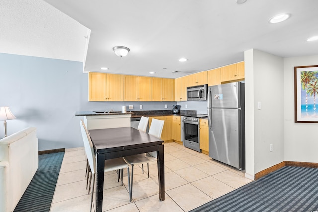 107 S Ocean Blvd Unit 1402, Myrtle Beach, SC 29577 - kitchen with stainless steel appliances, light brown cabinets, dark countertops, baseboards, and recessed lighting