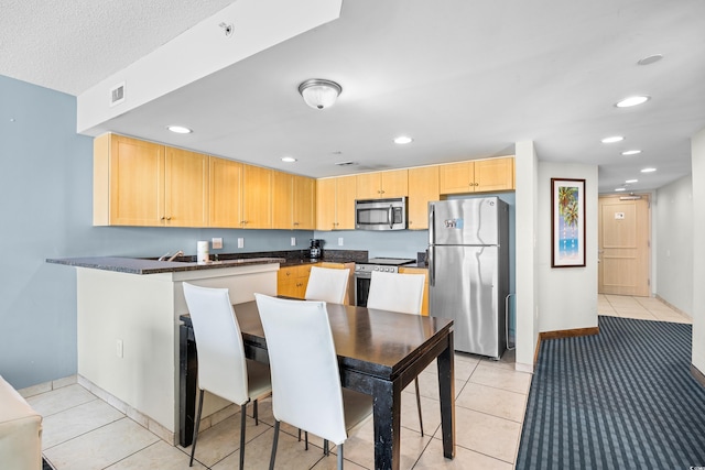 107 S Ocean Blvd Unit 1402, Myrtle Beach, SC 29577 - kitchen with stainless steel appliances, light brown cabinets, dark countertops, recessed lighting, and light tile patterned floors