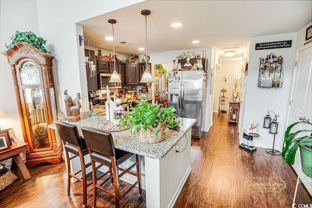 1147 Fairway Ln Unit 1147, Conway, SC 29526 - kitchen with stainless steel fridge with ice dispenser, dark wood-style flooring, a breakfast bar area, light stone countertops, and recessed lighting