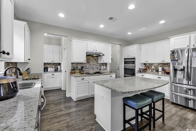 6239 Chadderton Cir, Myrtle Beach, SC 29579 - kitchen with stainless steel appliances, under cabinet range hood, a sink, tasteful backsplash, and white cabinetry
