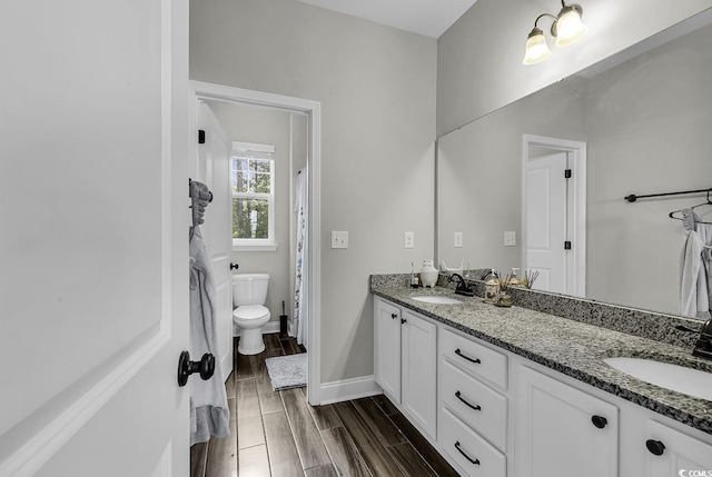 6239 Chadderton Cir, Myrtle Beach, SC 29579 - bathroom with double vanity, toilet, wood tiled floors, and baseboards