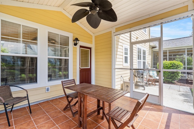 sunroom / solarium featuring vaulted ceiling, ceiling fan, and outdoor dining area
