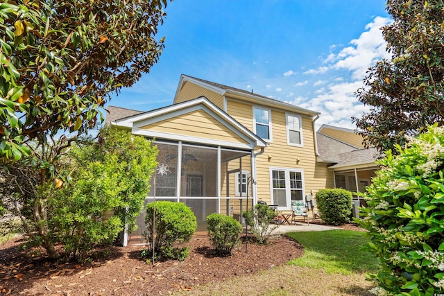 back of property with a sunroom and a patio area