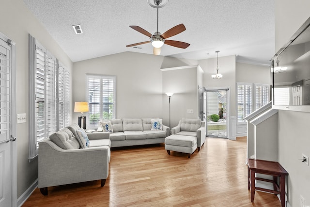 living room with vaulted ceiling, ceiling fan, a textured ceiling, and light wood finished floors