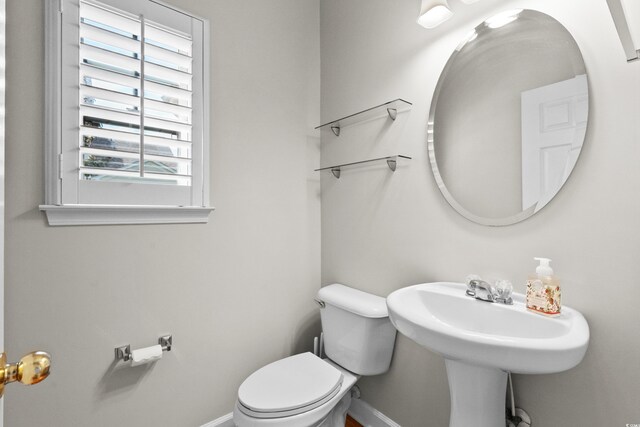 bathroom with toilet and baseboards