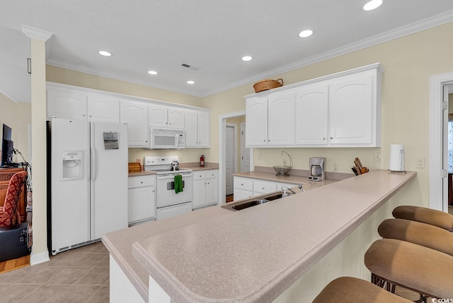 1729 Longleaf Dr, Myrtle Beach, SC 29575 - kitchen with white appliances, a sink, a breakfast bar area, a peninsula, and white cabinets