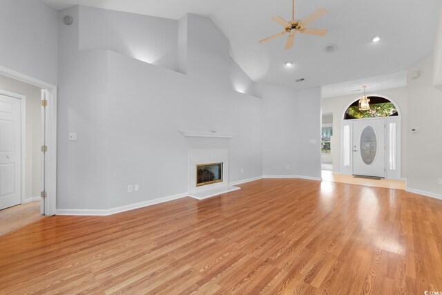 3107 Robyn Ct, Little River, SC 29566 - unfurnished living room featuring high vaulted ceiling, ceiling fan, light wood-style flooring, a glass covered fireplace, and baseboards
