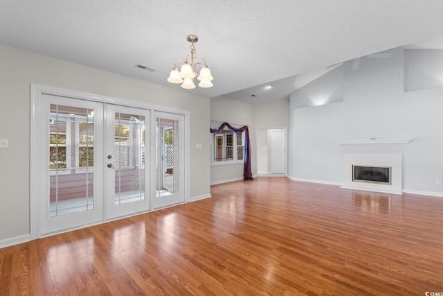 3107 Robyn Ct, Little River, SC 29566 - unfurnished living room featuring a chandelier, wood finished floors, baseboards, a textured ceiling, and vaulted ceiling