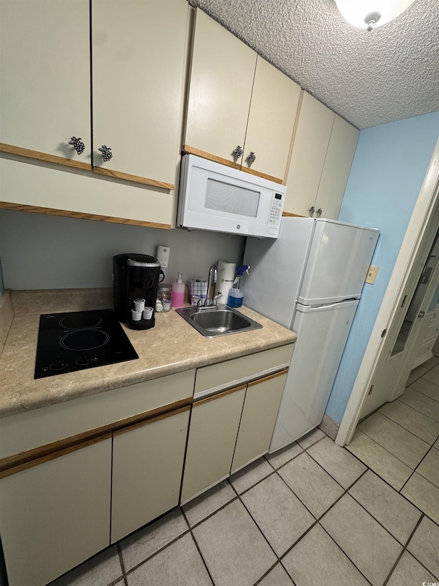 7500 N Ocean Blvd Unit 6120, Myrtle Beach, SC 29572 - kitchen with white appliances, light countertops, a textured ceiling, light tile patterned flooring, and cream cabinets